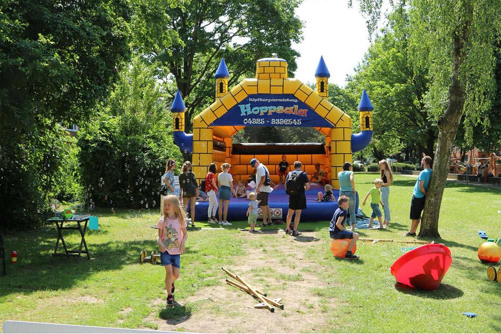 Hüpfburg Camelot mit spielenden Kindern bei einem Sommerfest